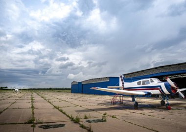 Hangarlar ve inanılmaz uçaklar podyumu güzel bir gökyüzünün arka planına karşı dekore ediyor.