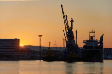 Gün batımında demirleme ve liman vinçleri