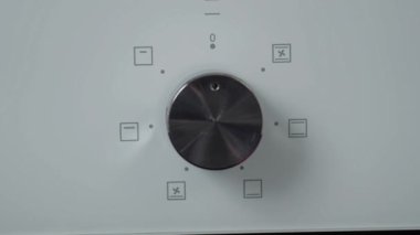 Metalik açma/kapatma düğmesi Ocak fırın. Yakın çekim görünümü. Modern beyaz fırın ön panel. Modern tasarım detayları. 