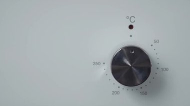 Metalik açma/kapatma düğmesi Ocak fırın. Yakın çekim görünümü. Modern beyaz fırın ön panel. Modern tasarım detayları. 