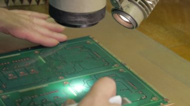 Bir kadın devre kartını denetler. Pcb yakın çekim. Modern elektronik temeli