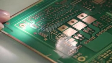 Bir kadın devre kartını denetler. Pcb yakın çekim. Modern elektronik temeli