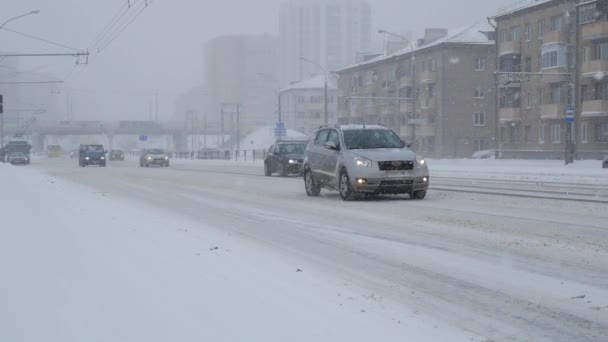 猛吹雪の条件が付いている都市の雪嵐 大雪の嵐の中 市内で運転のトラフィック — ストック動画
