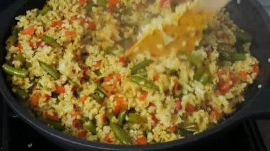 Bulgur yemek: bulgur pilavı. Adam bulgur ile kızarmış sebze karışımları. Sağlıklı taze sebze ile yemek. Bir tavada kızartma sebze.
