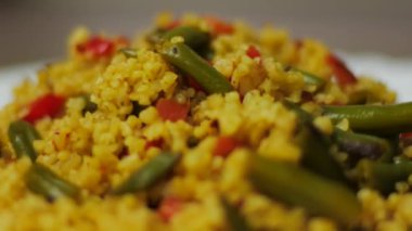 Bulgur yemek: bulgur pilavı. Adam bulgur ile kızarmış sebze karışımları. Sağlıklı taze sebze ile yemek. Bir tavada kızartma sebze.