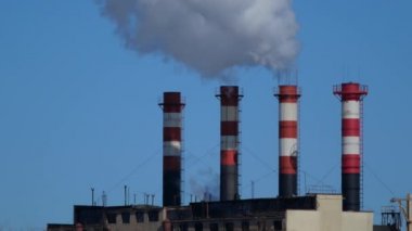 Endüstriyel fabrikalardan gelen hava kirliliği. Tüttüren endüstriyel borular. Beyaz pipolu kırmızı.