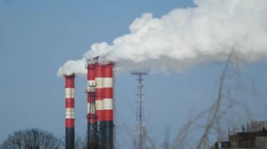 Endüstriyel fabrikalardan gelen hava kirliliği. Tüttüren endüstriyel borular. Beyaz pipolu kırmızı.
