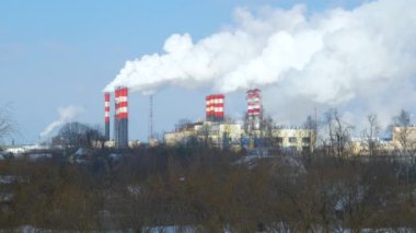 Endüstriyel fabrikalardan gelen hava kirliliği. Tüttüren endüstriyel borular. Beyaz pipolu kırmızı.