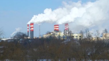 Endüstriyel fabrikalardan gelen hava kirliliği. Tüttüren endüstriyel borular. Beyaz pipolu kırmızı.