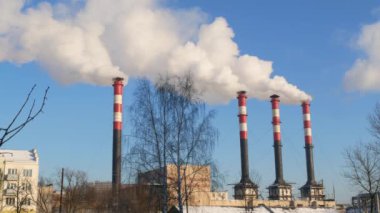 Endüstriyel fabrikalardan gelen hava kirliliği. Tüttüren endüstriyel borular. Beyaz pipolu kırmızı.