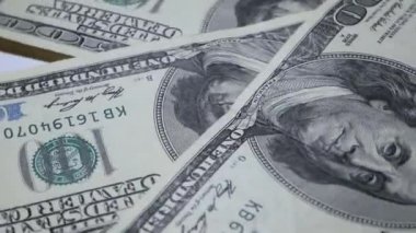 Yüz dolar faturaları bir masaya dönüyor. Yakın çekim. Döndürme kağıt para yakın çekim. Arka plan ile para Amerikan yüz dolar faturaları