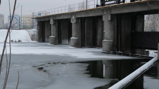 大坝以冬季场景为背景 冬天大坝的波涛汹涌的水 可见的结冰和冰柱 — 图库视频影像