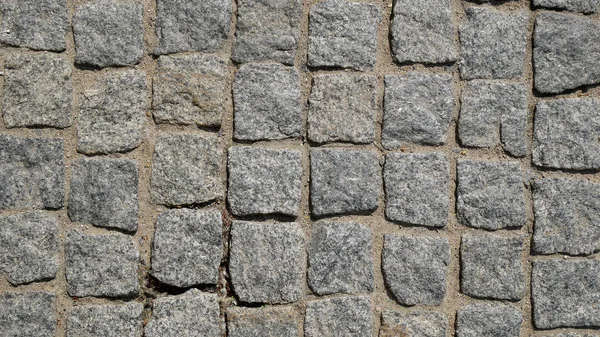 The Pavement Laid With Square Stone Cobbles Of Granite. Background.