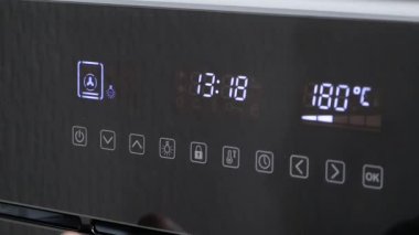 Modern siyah elektrikli fırın whith ön panel touch kontrol ve mavi dijital saat ve kişi el açar ve fırın kapı kapanır. Ev aletleri. 