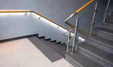 Kapalı merdiven basamakları paslanmaz çelik ve cam tırabzanlarla.