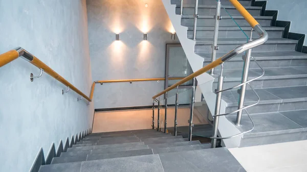 Kapalı merdiven basamakları paslanmaz çelik ve cam tırabzanlarla.