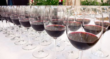 Kırmızı şarap kadehleri üst üste. Şarap tatma kutlaması için büfe masası. Gece hayatı, kutlama ve eğlence konsepti. 