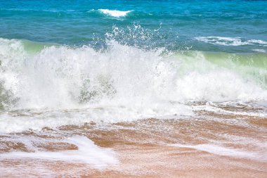 Kumsalda ağır mavi okyanus su sıçramalarına
