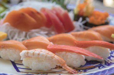 Sushi, sashimi ve dilimlenmiş turp ile Japon plaka