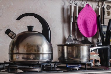 Mutfakta metal su ısıtıcısı ve pot yakıcı bir gaz sobası