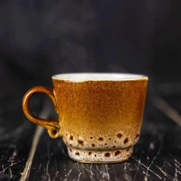 Una taza de café en una mesa de madera. Fondo oscuro —  Fotos de Stock