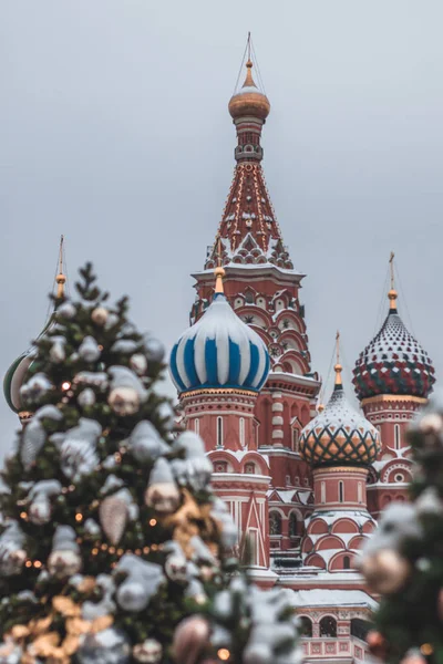 Árboles de Navidad borrosos en la Plaza Roja, Moscú. Árboles de Navidad y fondo de la Catedral de San Basilio — Foto de Stock