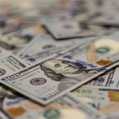 Yeni bir 100 dolar ABD para notu üzerinde Benjamin Franklins portre makro çekim, bir karışıklık çok daha özdeş para notları defocused arka plan ile.