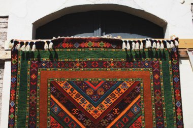 parlak renkli el yapımı halı eski bina balkonda asılı 