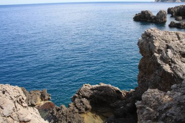 ısmarlayarak mavi denizde güneşli gün ile kayalık kıyı 