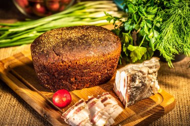 Çavdar ekmeği, domuz yağı ve turp sunl ışınları ahşap bir tahta üzerinde