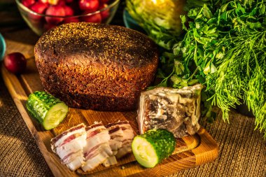 Çavdar ekmeği, domuz yağı ve turp sunl ışınları ahşap bir tahta üzerinde