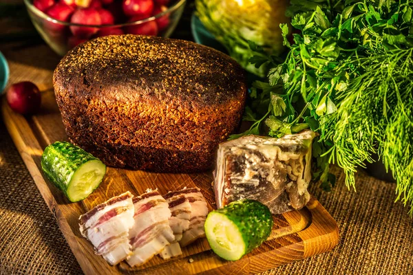 Çavdar ekmeği, domuz yağı ve turp sunl ışınları ahşap bir tahta üzerinde