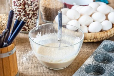 Un bir elekten inceleyip cam bir kase süte elenir..