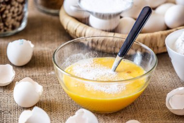 Çiğ yumurta ile cam bir kaseye un ekleyin.