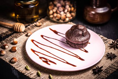 Bir restoranda pembe tabakta çikolatalı kek.