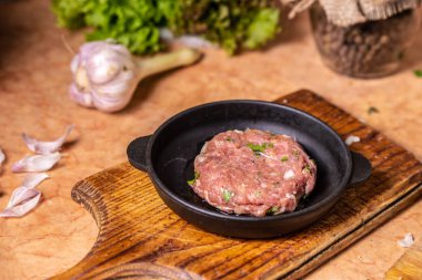 Ahşap bir tahta üzerinde ham pirzif ile demir kızartma tavası