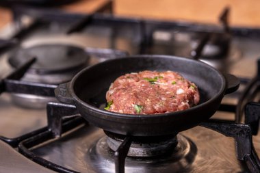 Gaz sobası üzerinde ham pirzama ile Demir tava.