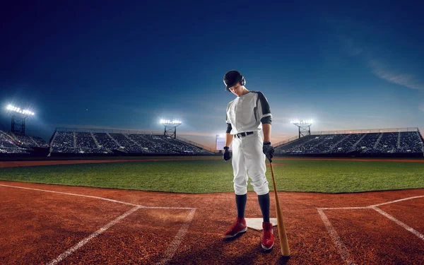 Baseball player at professional baseball stadium in evening duri