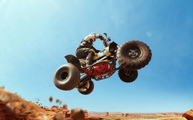 Toz bulutunda dörtlü bisiklet, arka planda kum ocağı. ATV Sürücüsü içeri