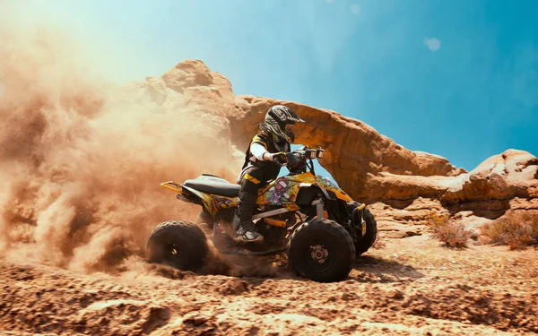 Quad bike in dust cloud, sand quarry on background. ATV Rider in