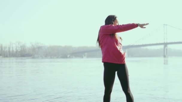 Νεαρή Γυναίκα Κάνει Άσκηση Κοντά Στο Ποτάμι — Αρχείο Βίντεο