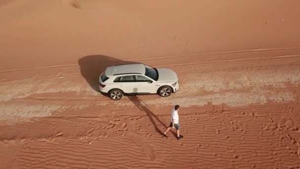 4K Vista aérea tras el nuevo e-tron en el desierto de Abu Dhabi. U.A.E. Coche eléctrico en el desierto — Vídeo de stock