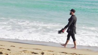 Barcelona'da soğuk ve dalgalı bir deniz kıyısında yürüyüş giysili bir adam