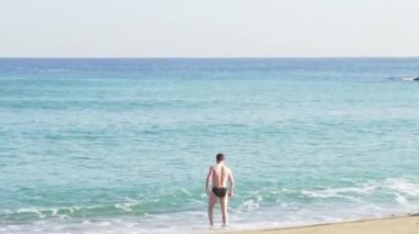 Cesur bir adam soğuk denizde yüzme goes