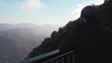 Gözlem güvertesinde adam Dağları nın güzel bir manzaraya görünüyor