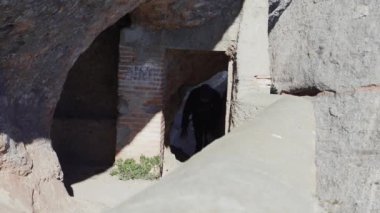 Korkuluk üzerine eğilerek bir dik dağ yamaç kenarında bir adam yürüyor