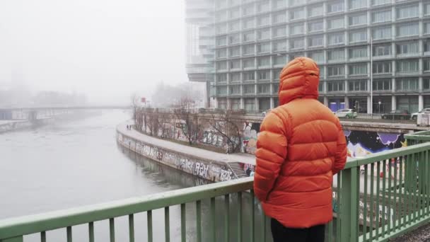 Le gars se tient sur le pont et regarde la ville dans le brouillard en Autriche — Video