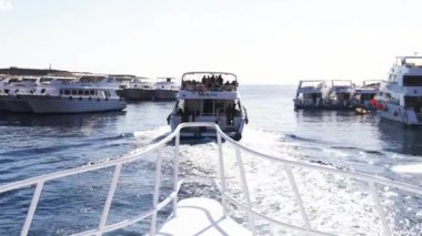 Teknede denize yelken açık. Deniz boyunca hareket eden beyaz motor gemisi, dalgalar yaratıyor. Sonsuz mavi gölet, beyaz bulutlar ile açık gökyüzü
