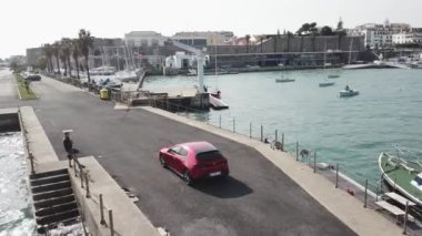 Hava drone yatlar ile iskele üzerinde duran araba etrafında uçar