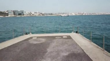 Havadan insansız hava aracı, büyük bir yatların yanından uçup, sahile yakın denizüzerinde uçuyor.